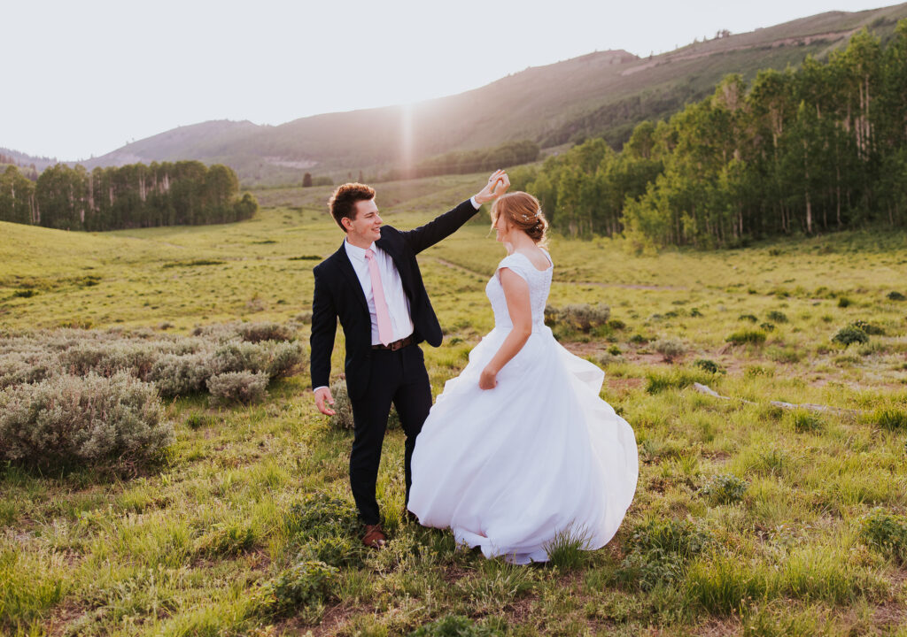 Bride twirls for groom in wedding dress near Guardsman's Pass, Utah