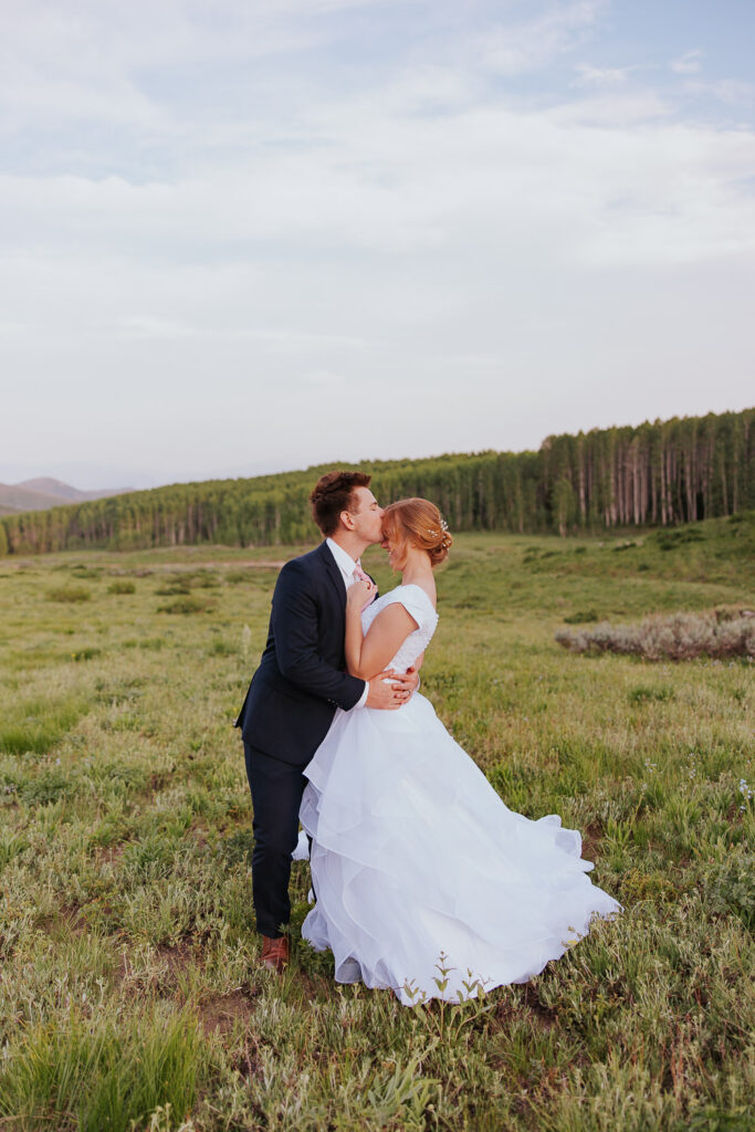 Groom kisses bride on forehead during Utah wedding