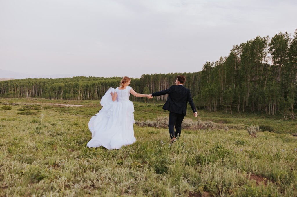 Celebration of Utah wedding ceremony in green field with trees
