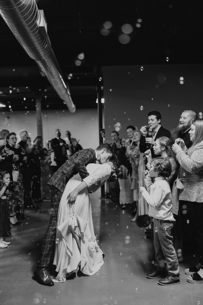 Bride and groom kiss during bubble wedding exit
