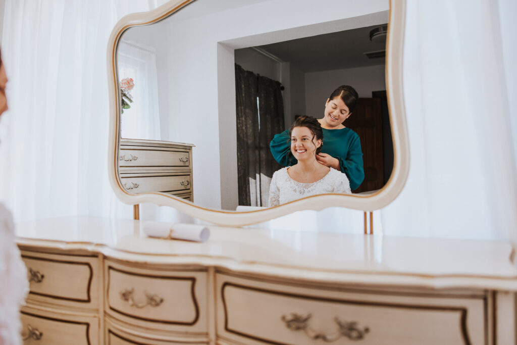 Mother and daughter get ready for wedding in mirror