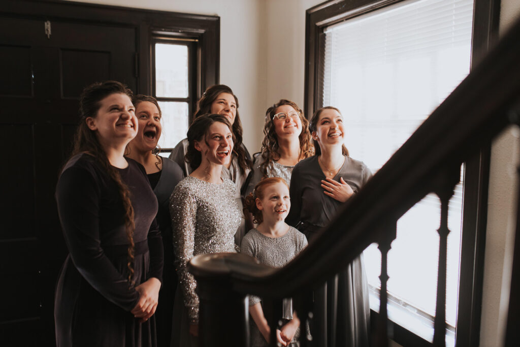 Bridesmaids anticipate the reveal of the bride in her dress