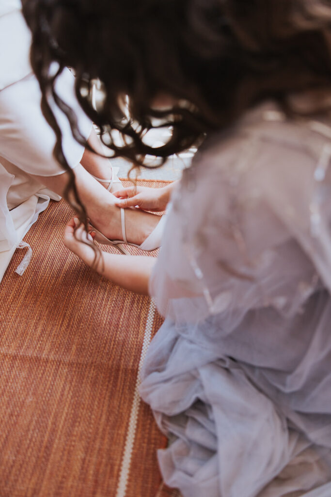 Maid of honor puts on bride's shoes