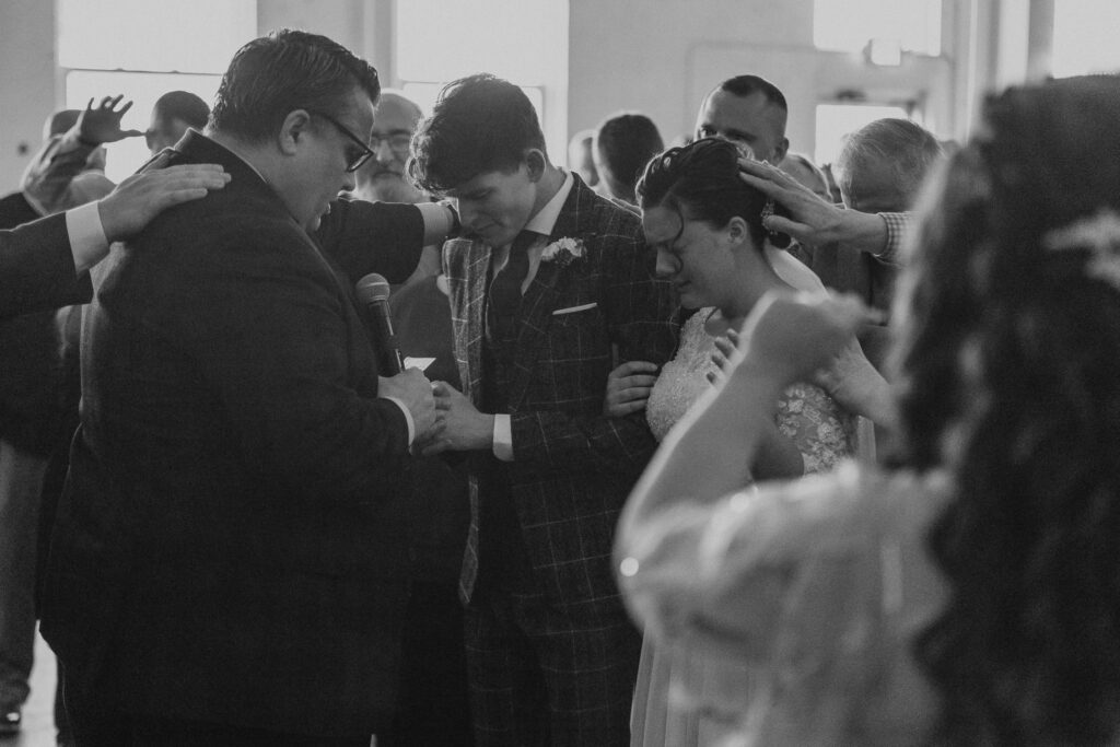 Bride and groom are blessed during prayer in Toledo, Ohio